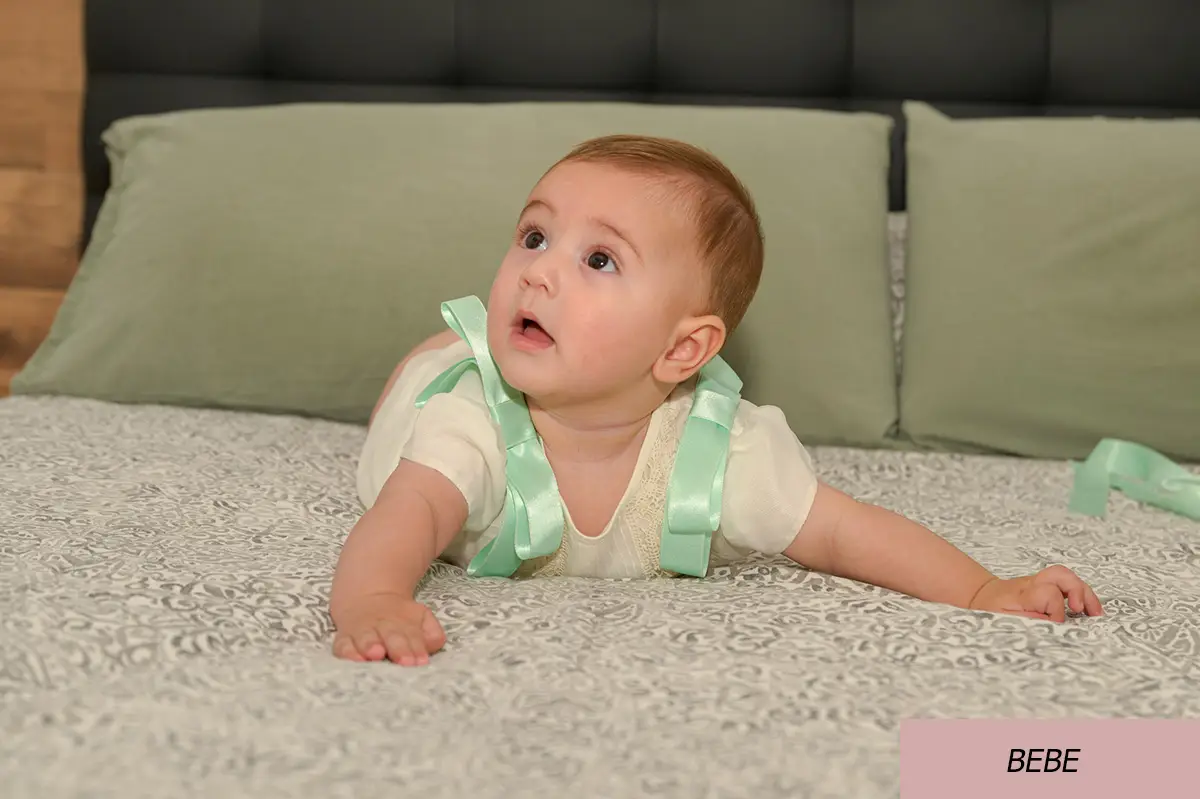 Imagen de un bebe encima de una cama